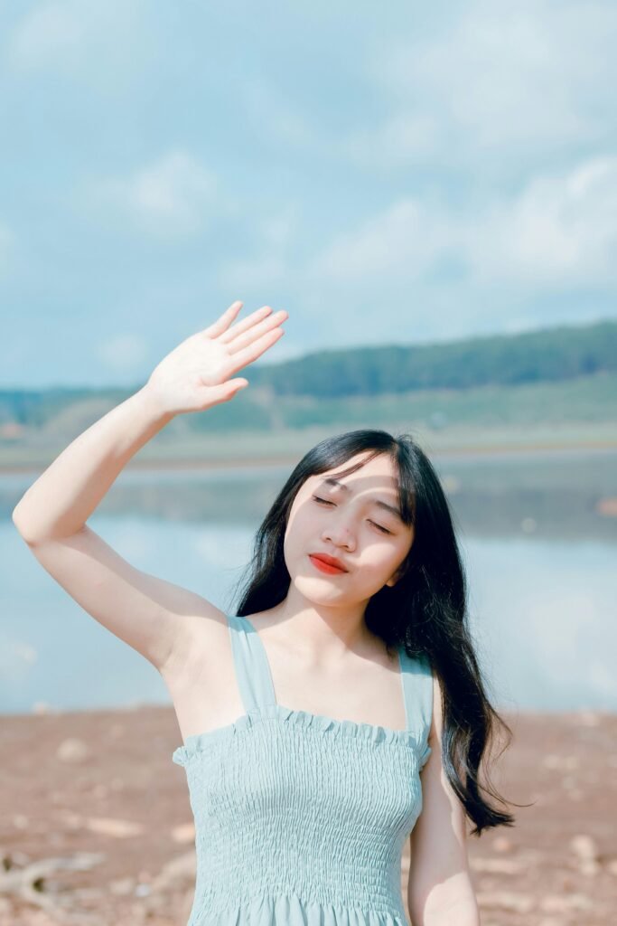 Asian woman in summer dress enjoying the sunny day by a lake.